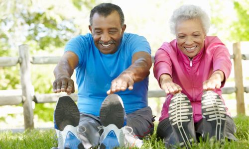 Senior African American Couple Exercising In Park